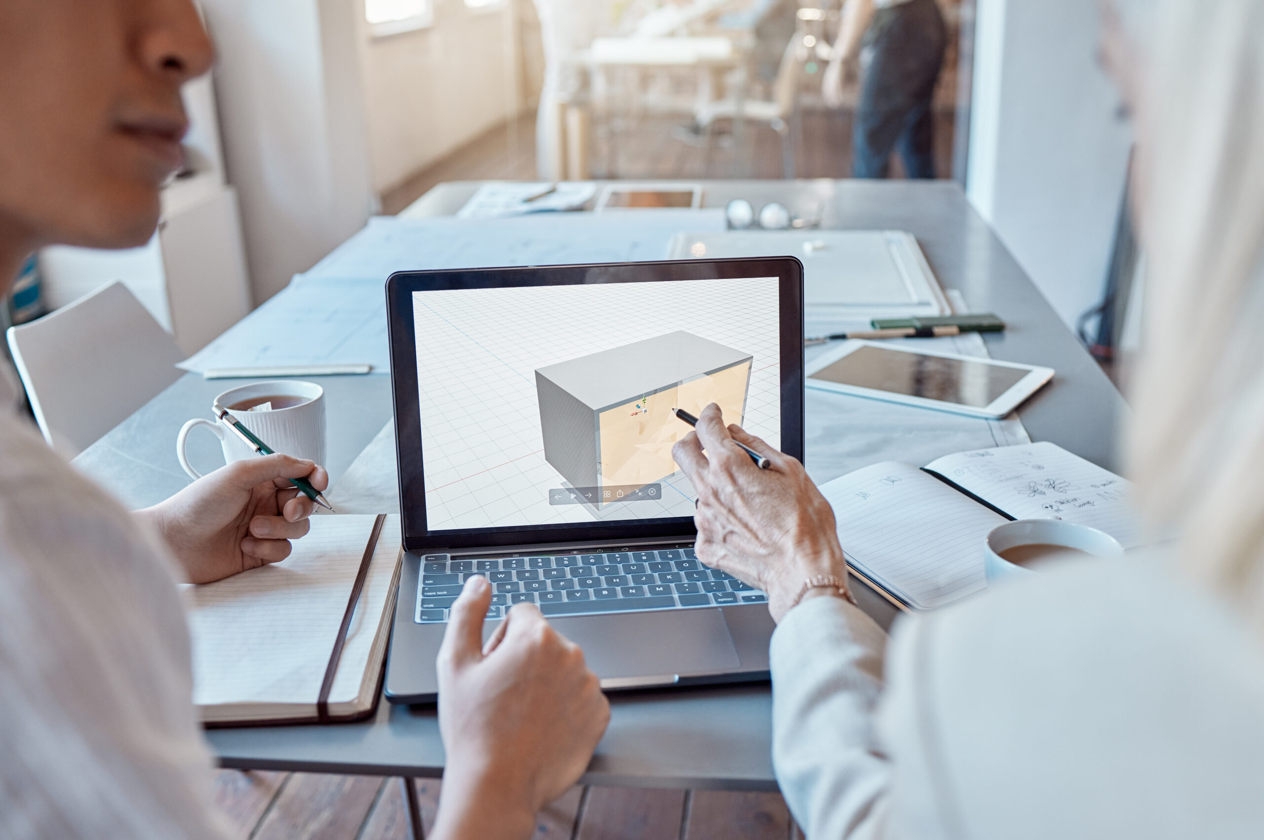 Architect, design engineer or contractor pointing to a 3d digital model on a laptop screen, discuss.